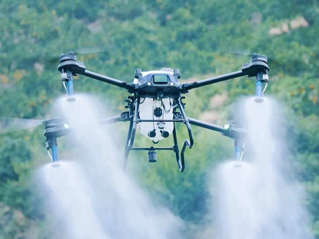 Drohne versprüht Flüssigkeit über Feld