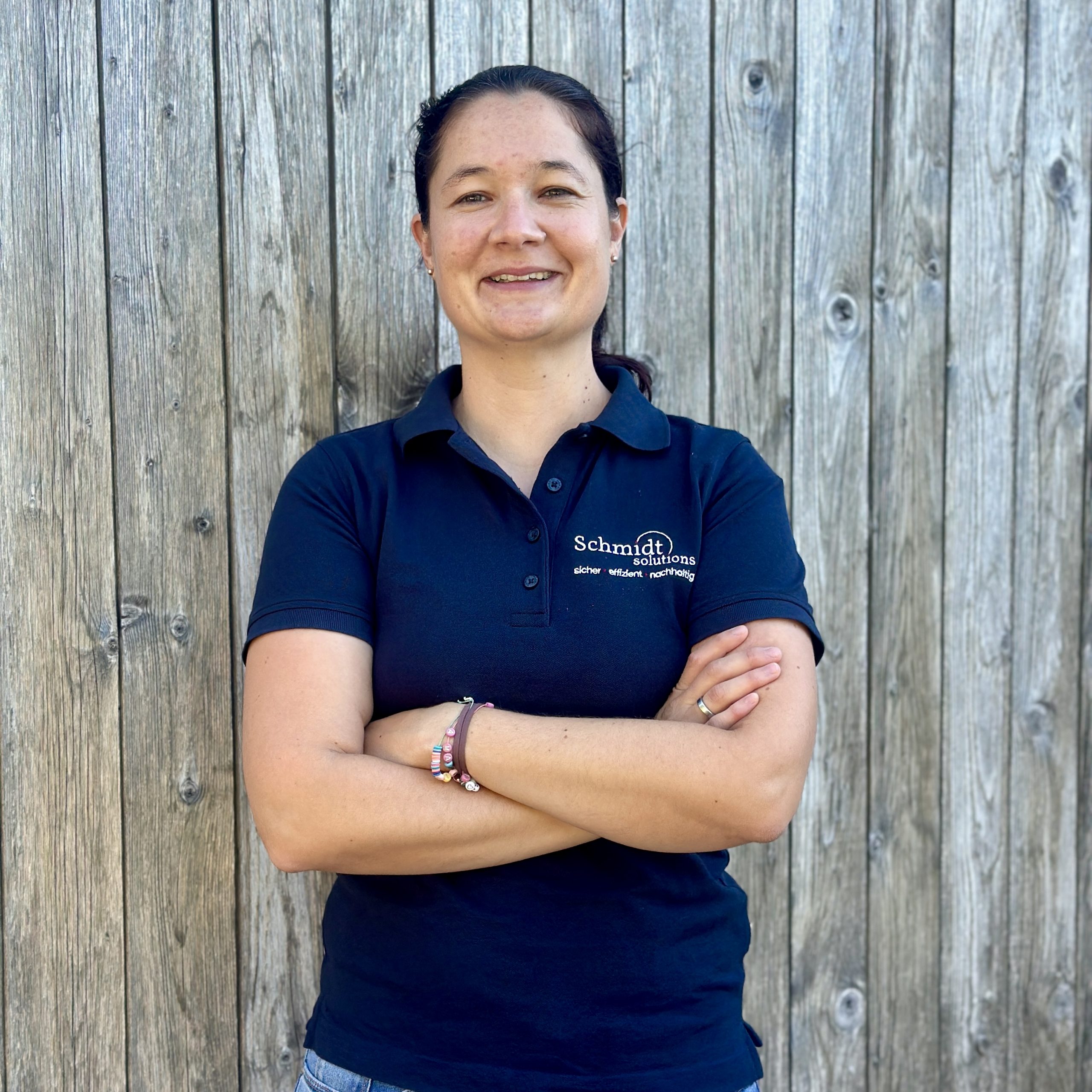 Frau in blauem Hemd mit verschränkten Armen.